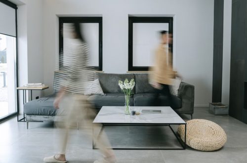 A stylish living room with minimalist decor featuring people in motion blur, creating dynamic energy.