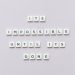 Motivational phrase 'It's impossible until it's done' arranged with Scrabble tiles on a gray background.